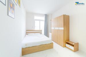 a bedroom with a bed and a wooden cabinet at Trang Dream House Phan Rang in Kinh Dinh