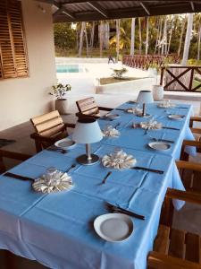 una mesa larga con un paño de mesa azul y sillas en Dive Planet Mafia Island, en Utende