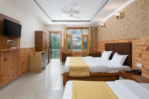 a hotel room with two beds and a flat screen tv at Mcleodgunj Mountain view in Dharamshala