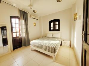 a bedroom with a white bed and a window at IN LUXOR Nile Apartments in Luxor