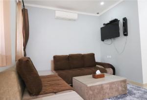 ein Wohnzimmer mit einem Sofa und einem TV in der Unterkunft Diyar Villas Puncak K3/2 in Puncak