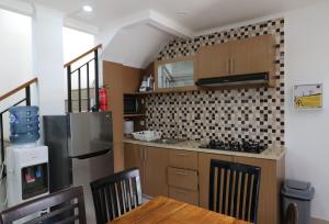 a kitchen with a refrigerator and a table with chairs at Diyar Villas Puncak K3/2 in Puncak