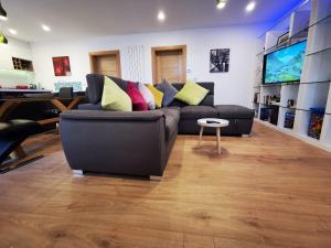 a living room with a black couch with colorful pillows at Ard Kielin Apartment Luxury 2 bedroom in Killarney in Killarney