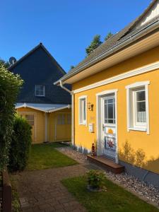 a yellow house with a yard at Ferienhaus Mein Panama in Zingst