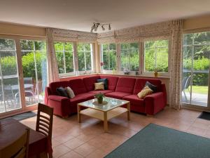 a living room with a red couch and a table at Ferienhaus Mein Panama in Zingst
