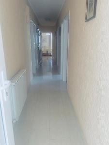 a hallway with a white tile floor in a house at Apartmani Rab in Kampor