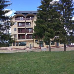 ein großes Gebäude mit Bäumen davor in der Unterkunft Apartman Petar in Nova Varoš