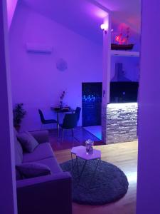 a purple living room with a couch and a table at Apartmani Ferdi in Trogir