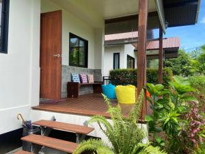 a house with a wooden deck with benches and plants at Sean Sabai Home e Ristobar in Taling Ngam Beach