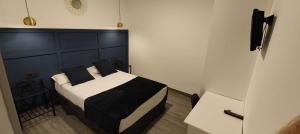 1 dormitorio con 1 cama con cabecero negro en ROOMS Los MONTES en Granada