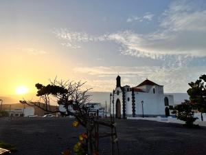 a small white church with the sunset in the background at Modern Luxury Villa in Poris de Abona
