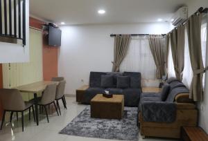 uma sala de estar com um sofá azul e uma mesa em Diyar Villas Puncak K2/29 em Puncak