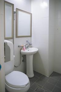 bagno bianco con servizi igienici e lavandino di Inhere Guesthouse a Gyeongju
