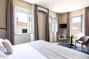 une chambre d'hôtel avec un lit et deux chaises dans l'établissement Residence Pidrinella, à LʼÎle-Rousse