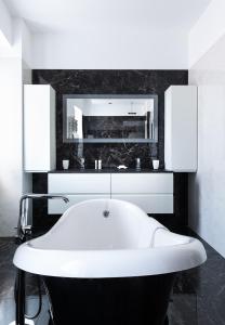 La salle de bains est pourvue d'une baignoire blanche et d'un miroir. dans l'établissement Residence Pidrinella, à LʼÎle-Rousse