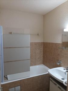 a bathroom with a bath tub and a sink at Studio-cabine Résidence les Rennes in Prémanon