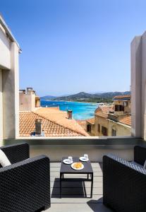 uma varanda com mesa e cadeiras e vista para o oceano em Residence Pidrinella em L'Île-Rousse