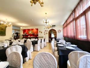 een eetkamer met tafels en witte stoelen bij HOTEL RINASCIMENTO in Montecatini Terme