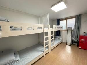 Cette chambre comprend 2 lits superposés et une fenêtre. dans l'établissement Inhere Guesthouse, à Gyeongju