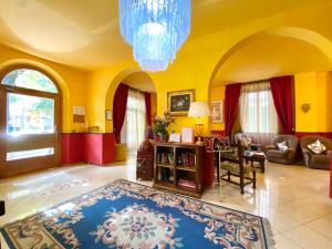 een woonkamer met gele muren en een blauw tapijt bij HOTEL RINASCIMENTO in Montecatini Terme