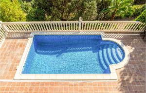 una piscina azul en un suelo de ladrillo con una valla en Awesome Home In Palafolls With Outdoor Swimming Pool, en Palafolls