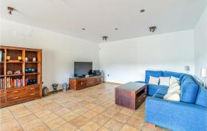 uma sala de estar com um sofá azul e uma televisão em Stunning Home In Palafolls em Palafolls