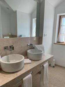 a bathroom with a sink and a large mirror at Casa Guardiao in Chaves