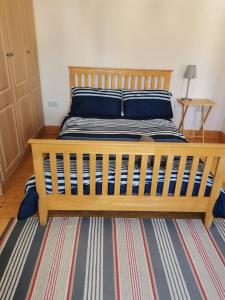 a wooden bed with blue pillows on it in a room at Seabury Holiday Home, Rosslare Strand, County Wexford - Sleeps 7 in Rosslare