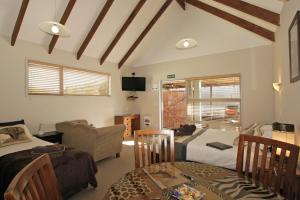 een kamer met 2 bedden en een tafel en een bank bij Big Five Motel in Palmerston North