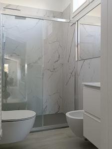 een badkamer met een douche, een toilet en een wastafel bij Residenza Adamo ed Eva in Pordenone
