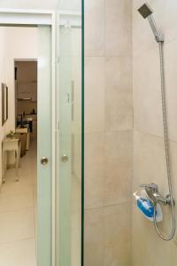 y baño con ducha y puerta de cristal. en Unique 1 bedroom in hearth of old city Valetta en La Valeta