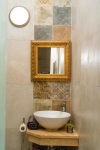 y baño con lavabo blanco y espejo. en Unique 1 bedroom in hearth of old city Valetta en La Valeta