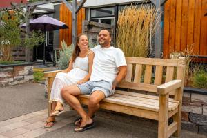 a man and a woman sitting on a bench at RCN Vakantiepark Toppershoedje in Ouddorp
