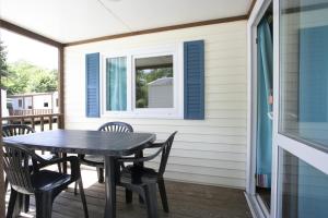 - une table et des chaises sur une terrasse couverte avec une fenêtre dans l'établissement La Bastide, à Mazères