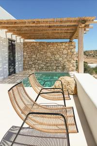two chairs sitting next to a swimming pool at Mystic Villas Koufonisi in Koufonisia