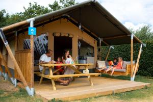 een gezin aan een tafel in een tent bij RCN Vakantiepark Toppershoedje in Ouddorp