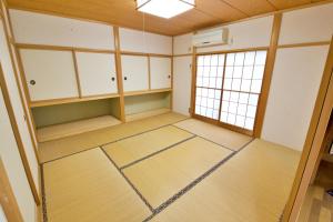 an empty room with white cabinets and a window at ヴィラ四季の丘 