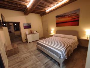 een slaapkamer met een bed in een kamer met houten vloeren bij The View - Sunset & Relax - Suite - Appartamenti Vista Lago in Passignano sul Trasimeno