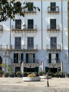 ein großes weißes Gebäude mit Fenstern und Balkonen in der Unterkunft Kalamarina Rooms in Palermo