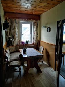 sala de estar con mesa y ventana en Gehlberger Landhaus am Schneekopf / Ferienwohnung en Suhl