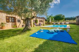 niebieski koc w trawie obok basenu w obiekcie Ideal Property Mallorca - Es Puput w mieście Petra