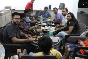 Manī MājraHotel Red Apple Near Railway Station Chandigarh的一群人围坐在桌旁吃饭