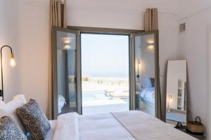 um quarto com uma cama e uma porta de vidro deslizante em Lavadoze Luxury Suites em Éxo Goniá