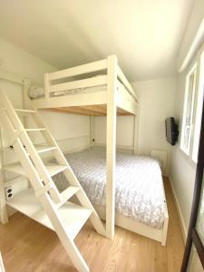 a bedroom with two bunk beds and a ladder at Superbe appartement vue sur la forêt in Les Angles