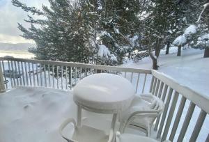 a white chair sitting on a balcony covered in snow at Superbe appartement vue sur la forêt in Les Angles