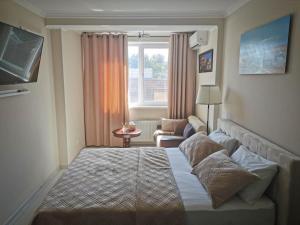 a hotel room with a bed and a window at Lovely central 1BR apartment with a balcony in Chişinău