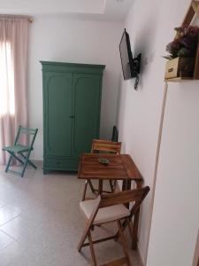 Habitación con armario verde, mesa y sillas. en FarmaMia, en Ascea