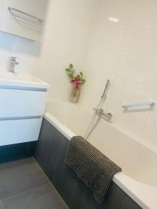 a bathroom with a sink and a bath tub with a towel at Home Inn Zandvoort the First Floor, 4 Persons, 2 bedrooms, free parking in Zandvoort