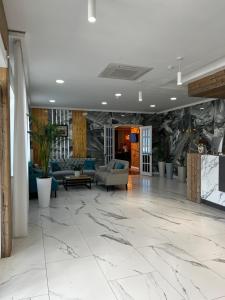 eine Lobby mit Marmorboden und Sofas in der Unterkunft KRich Hotel Aktobe in Aqtöbe