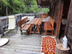 a wooden deck with a picnic table and a chair at Ferienwohnung Oberpursteinhof in Campo Tures